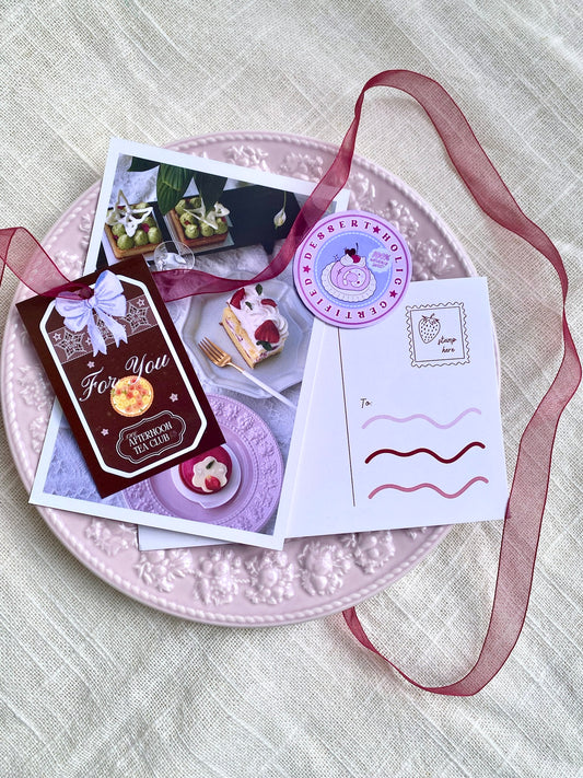 Stationery items including cards and a ribbon on a textured surface