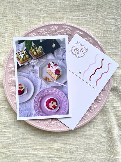 Card with dessert images on a pink plate with a white envelope